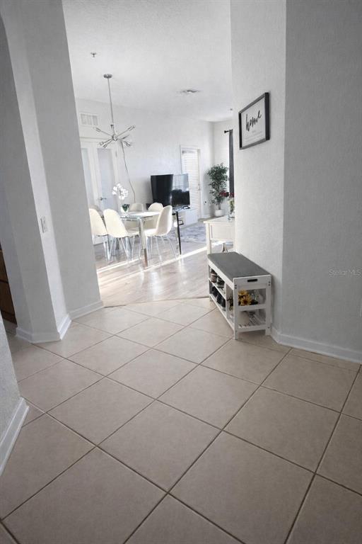 A tiled entryway leads into a dining area with light wood flooring and a chandelier — 3344 ROBERT TREND JONES DRIVE, ORLANDO, FL