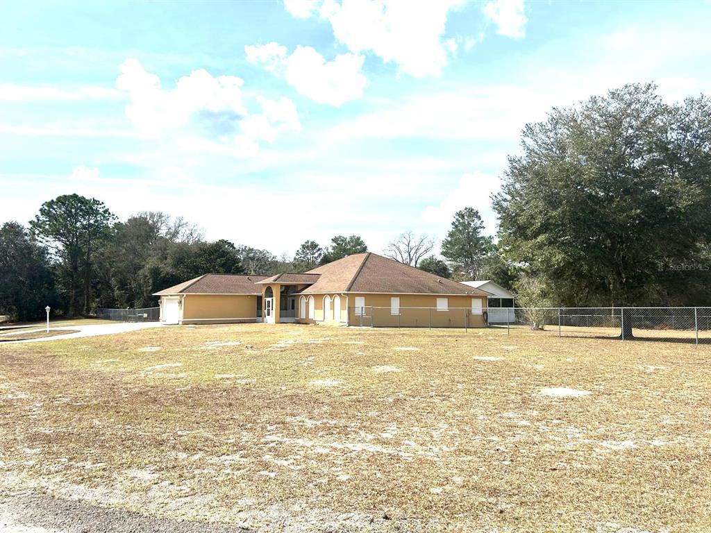 A tan, single-story house with a brown roof sits on a large, grassy lot — 0 SW 163RD STREET ROAD, OCALA, FL