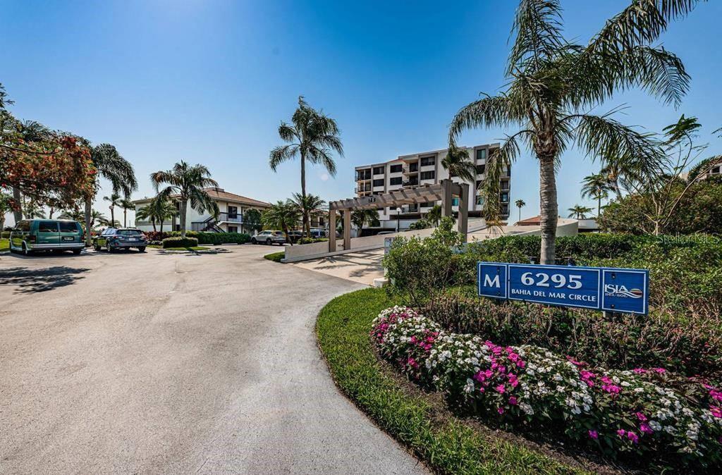 A paved driveway leads toward a multi-story apartment building surrounded by palm trees — 6295 BAHIA DEL MAR CIRCLE UNIT 505, ST PETERSBURG, FL