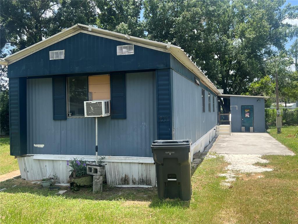 A blue mobile home with a window air conditioner and a concrete driveway — 2536 CANNON STREET, LAKELAND, FL
