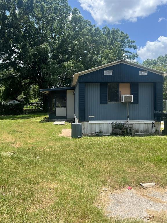 A blue mobile home with a screened-in porch sits on a grassy lot — 2536 CANNON STREET, LAKELAND, FL