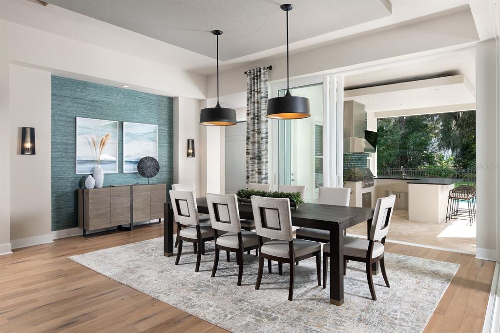 A dining room with a teal accent wall, dark wood table, and an outdoor kitchen view — 0000 SE 47TH LOOP, OCALA, FL