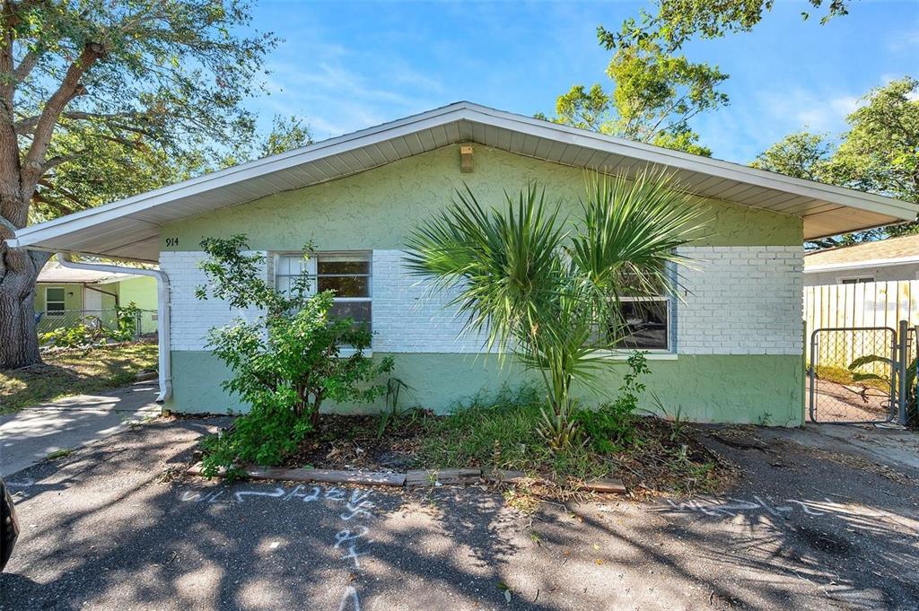 A single-story house with a green and white exterior features a palm tree in front — 914 LAKE PALMS DRIVE, LARGO, FL
