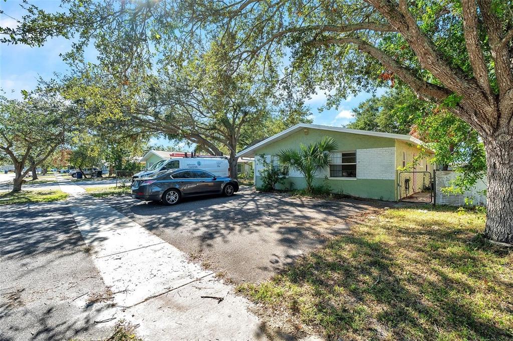 A single-story house with a green and white exterior sits behind a paved driveway — 914 LAKE PALMS DRIVE, LARGO, FL