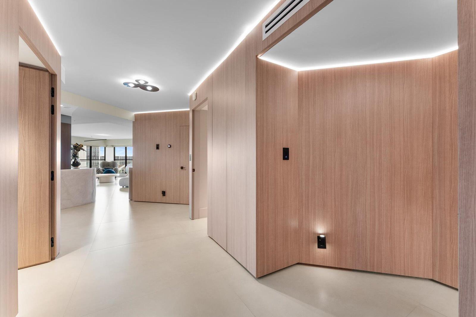 A hallway with light wood paneling, recessed LED lighting, and light-colored tile flooring — 4605 S Ocean Boulevard # 7b, Highland Beach FL 33487, HIGHLAND BEACH, FL
