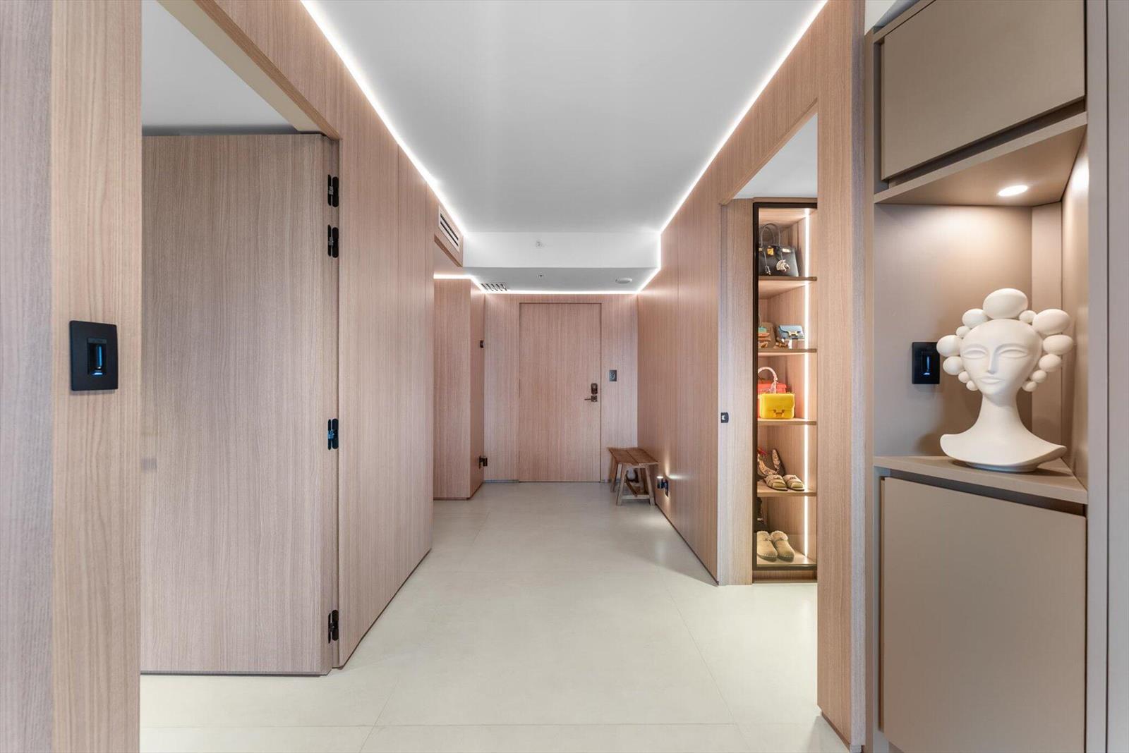 A modern hallway features light wood paneling, recessed ceiling lighting, and a built-in display shelf — 4605 S Ocean Boulevard # 7b, Highland Beach FL 33487, HIGHLAND BEACH, FL