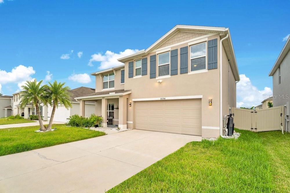 A two-story suburban house with a beige stucco exterior and a two-car garage — 35704 DOVELAND DRIVE, ZEPHYRHILLS, FL