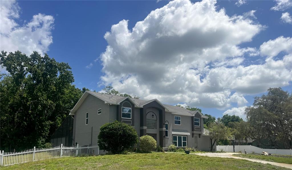 A two-story gray house with a multi-gabled roof and a paved driveway — 10655 LAKEVIEW DRIVE, NEW PORT RICHEY, FL