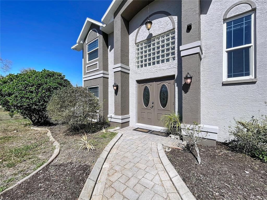 A two-story house with a gray stucco exterior, a paved driveway, and a front entrance — 10655 LAKEVIEW DRIVE, NEW PORT RICHEY, FL