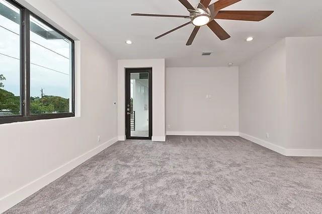A carpeted room features a ceiling fan, a large window, and a glass-paneled door — FORT LAUDERDALE, FL