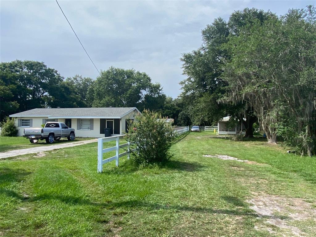 A single-story house with a white fence and a parked truck in the front yard — 4316 E KNIGHTS GRIFFIN ROAD, PLANT CITY, FL