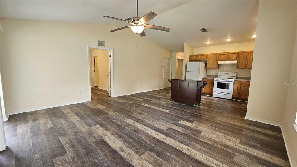 An open-concept living room and kitchen featuring wood-look flooring and a ceiling fan — 6290 W OAK PARK BOULEVARD, HOMOSASSA, FL