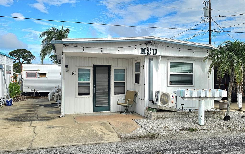 A white mobile home with a front porch, a small patio, and a row of mailboxes — 41 2ND STREET, BRADENTON, FL