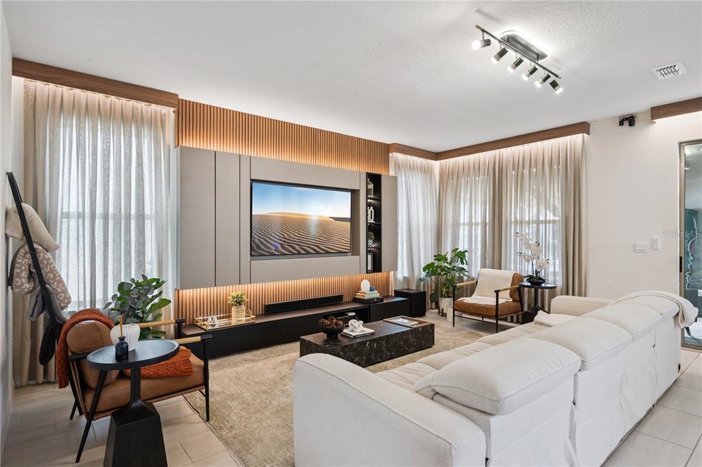 A modern living room features a slatted wood accent wall with a built-in television — 17070 WATER SPRING BOULEVARD, WINTER GARDEN, FL