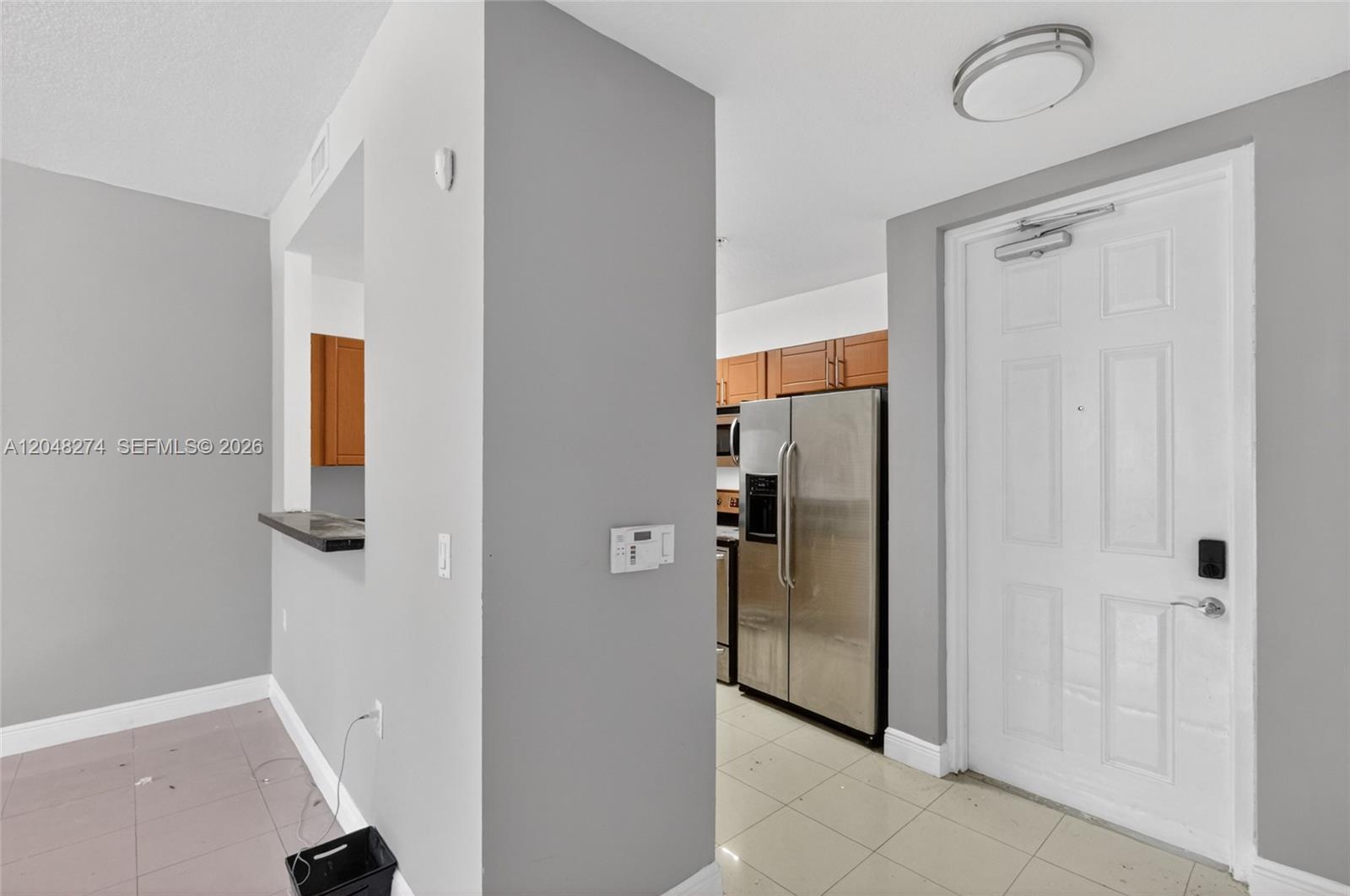A view of a kitchen with stainless steel appliances and a white entry door — 652 NE 63rd St # 103, Miami FL 33138, MIAMI, FL