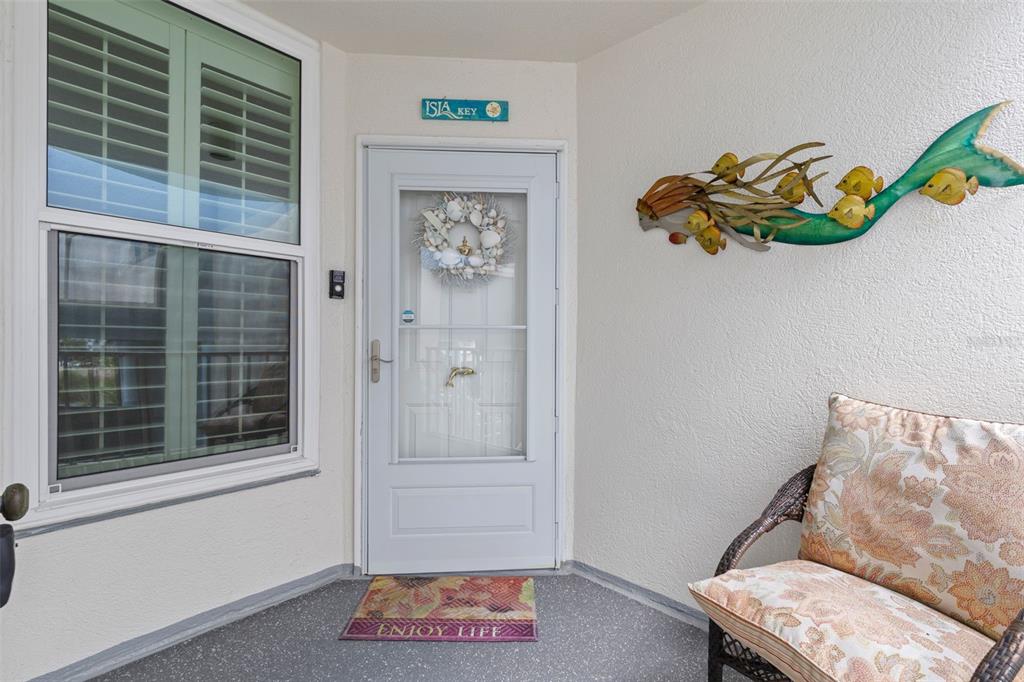 A front porch features a white door with a shell wreath and a mermaid wall sculpture — 5279 ISLA KEY BOULEVARD S UNIT 413, ST PETERSBURG, FL