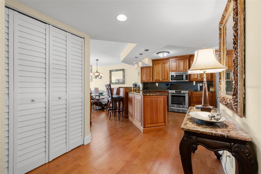 A kitchen with wood cabinets and an island opens into a dining area with hardwood floors — 5279 ISLA KEY BOULEVARD S UNIT 413, ST PETERSBURG, FL