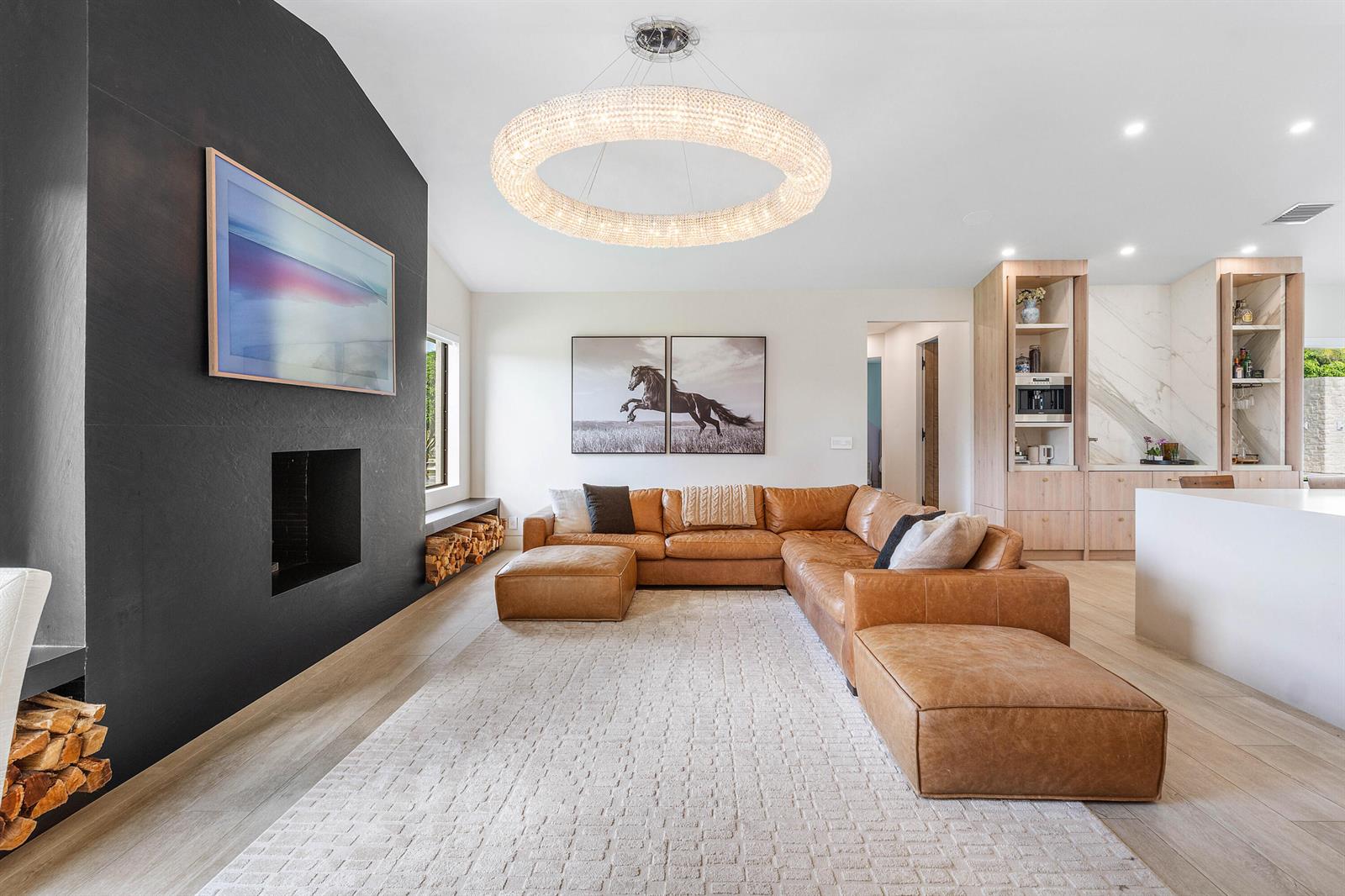 A living room features a large leather sectional, a black fireplace wall, and a crystal chandelier — 11173 Manatee, Lake Worth FL 33449, LAKE WORTH, FL