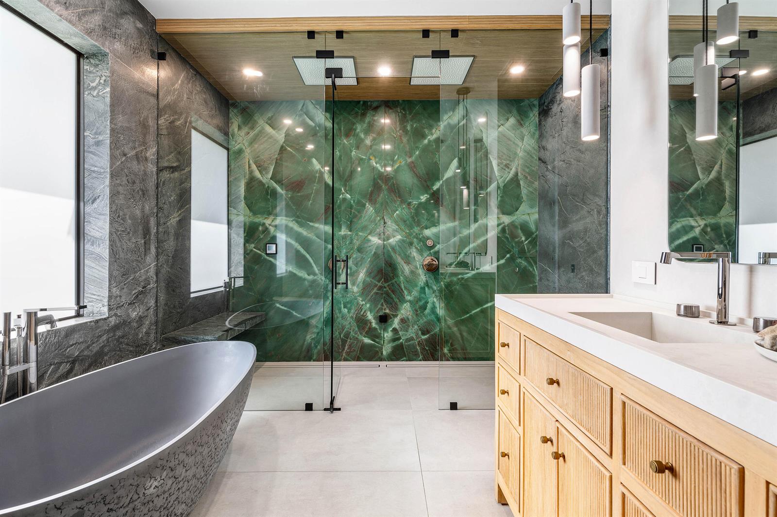A modern bathroom features a green marble shower wall, a gray soaking tub, and wood cabinetry — 11173 Manatee, Lake Worth FL 33449, LAKE WORTH, FL