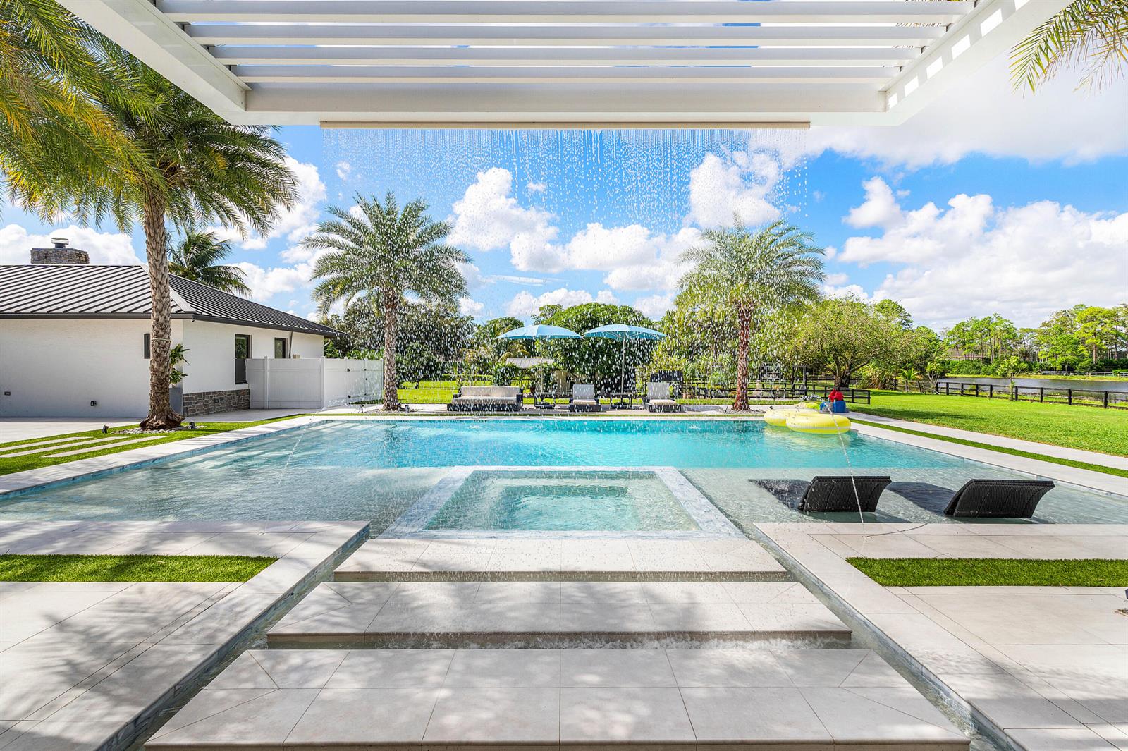 A backyard swimming pool with a spa, water feature, and lounge chairs under a pergola — 11173 Manatee, Lake Worth FL 33449, LAKE WORTH, FL