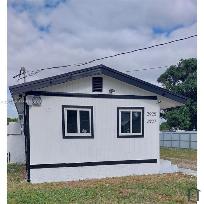 The exterior of a small, white, single-story house with black trim and two windows — 2927 NW 60th St, Miami FL 33142, MIAMI, FL