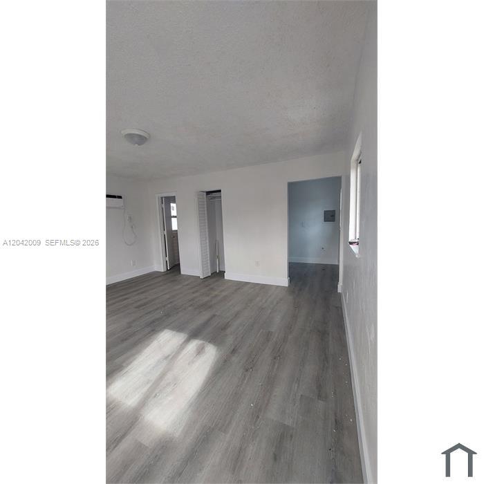An interior view of a room with light gray wood-look flooring and white walls — 2927 NW 60th St, Miami FL 33142, MIAMI, FL