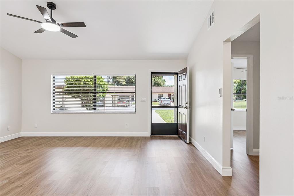 The exterior of a house features a front porch with seating and a dark door — 12441 ORANGEWOOD CIRCLE, TAVARES, FL