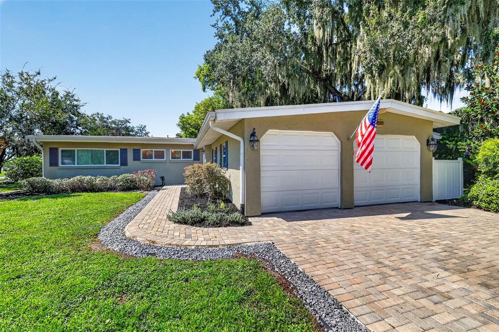 A single-story house with a two-car garage, a paved driveway, and a front lawn — 2434 TRACE AVE, BELLE ISLE, FL