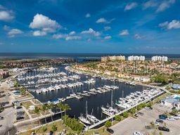 An aerial view of a marina filled with boats next to a coastal residential complex — 3220 SOUTHSHORE DRIVE UNIT 22C, PUNTA GORDA, FL