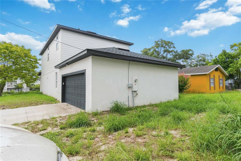 A white exterior wall features a dark-framed window, a black door, and a covered porch — 426 S HUDSON STREET, ORLANDO, FL