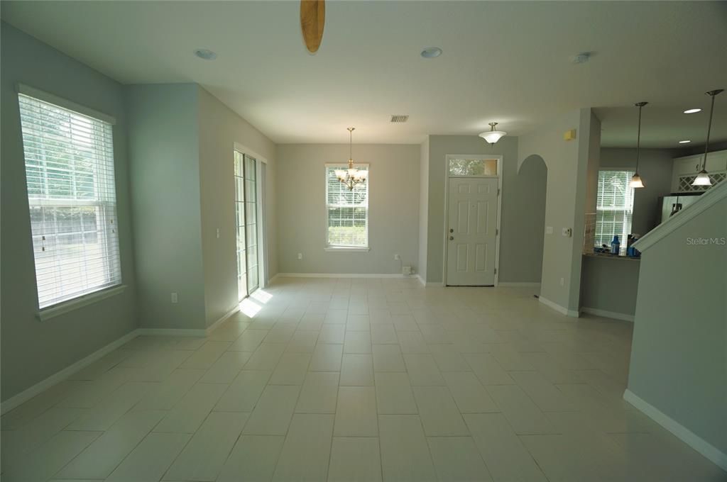 A bright, open-concept living and dining area features light gray walls and white tile flooring — 7001 INTERBAY BOULEVARD UNIT 236, TAMPA, FL
