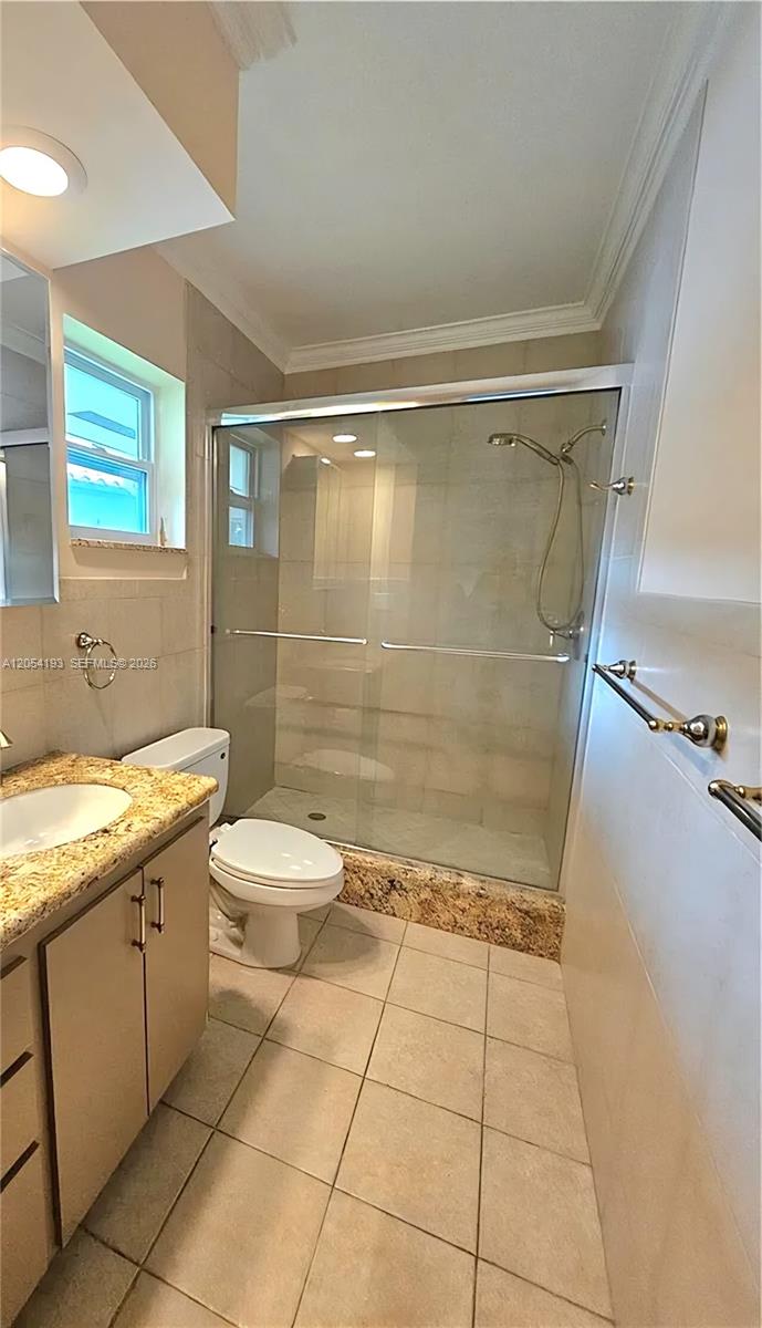 A bathroom features a granite-topped vanity, a tiled shower with glass doors, and beige flooring — 4602 King Palm Dr, Tamarac FL 33319, TAMARAC, FL