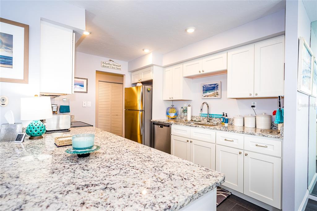 A kitchen features white cabinets, granite countertops, stainless steel appliances, and a large island — 707 S GULFSTREAM AVENUE UNIT 602, SARASOTA, FL
