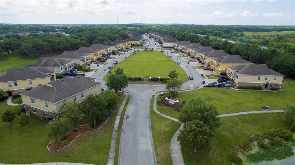 An aerial view shows a residential neighborhood with townhomes surrounding a central grassy area — 2148 BETSY ROSS LANE UNIT 2148, ST CLOUD, FL