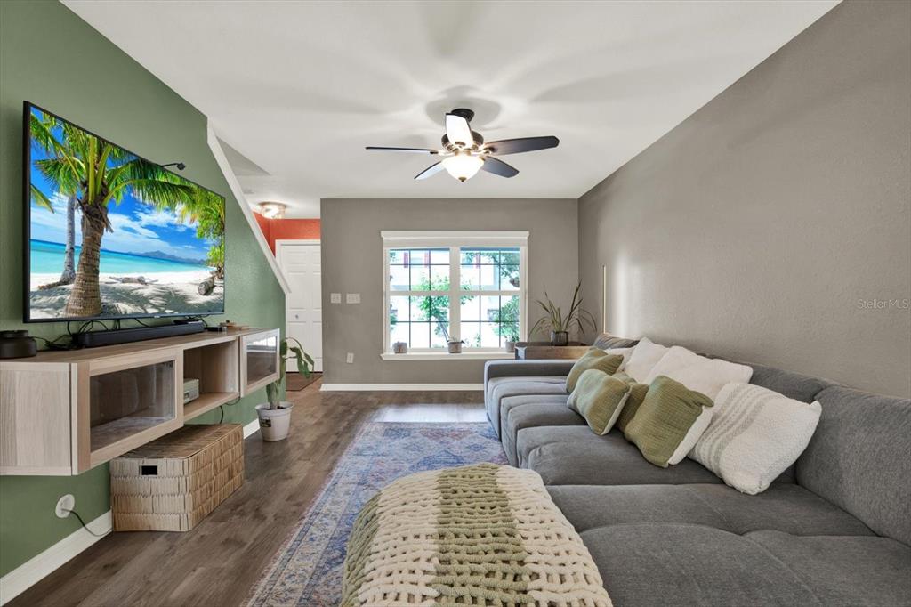 A living room features a gray sectional sofa, a wall-mounted television, and a ceiling fan — 3017 MOJAVE OAK DRIVE, VALRICO, FL