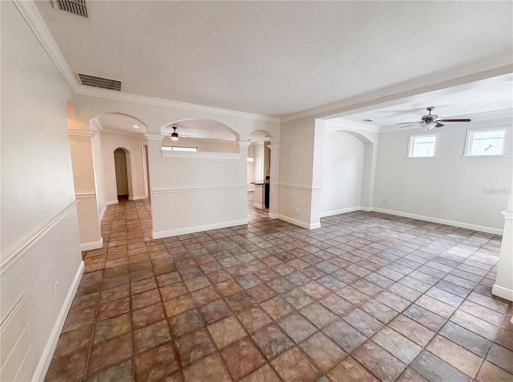 An open-concept living area features beige walls, crown molding, and multi-colored square floor tiles — 3379 MORELYN CREST CIRCLE, ORLANDO, FL
