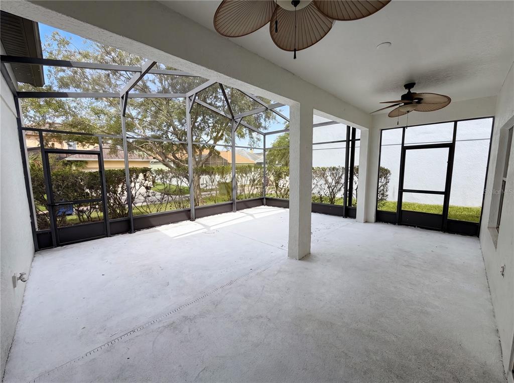 A screened-in patio features a concrete floor, two ceiling fans, and views of landscaping — 3379 MORELYN CREST CIRCLE, ORLANDO, FL