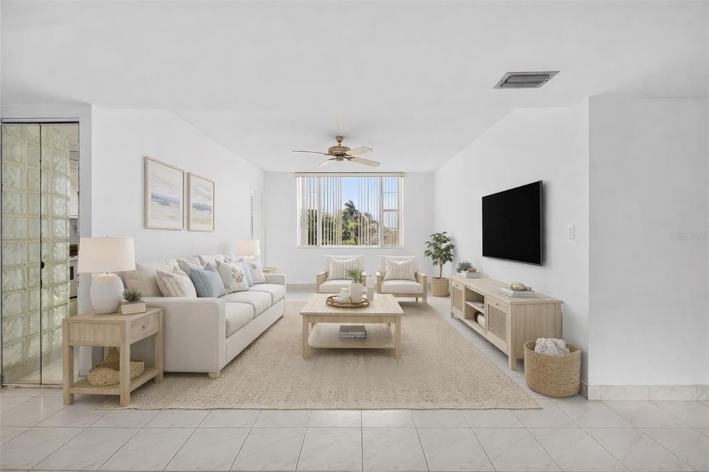 A bright living room features a white sofa, two armchairs, a coffee table, and television — 1820 NEW PALM WAY UNIT 306, BOYNTON BEACH, FL
