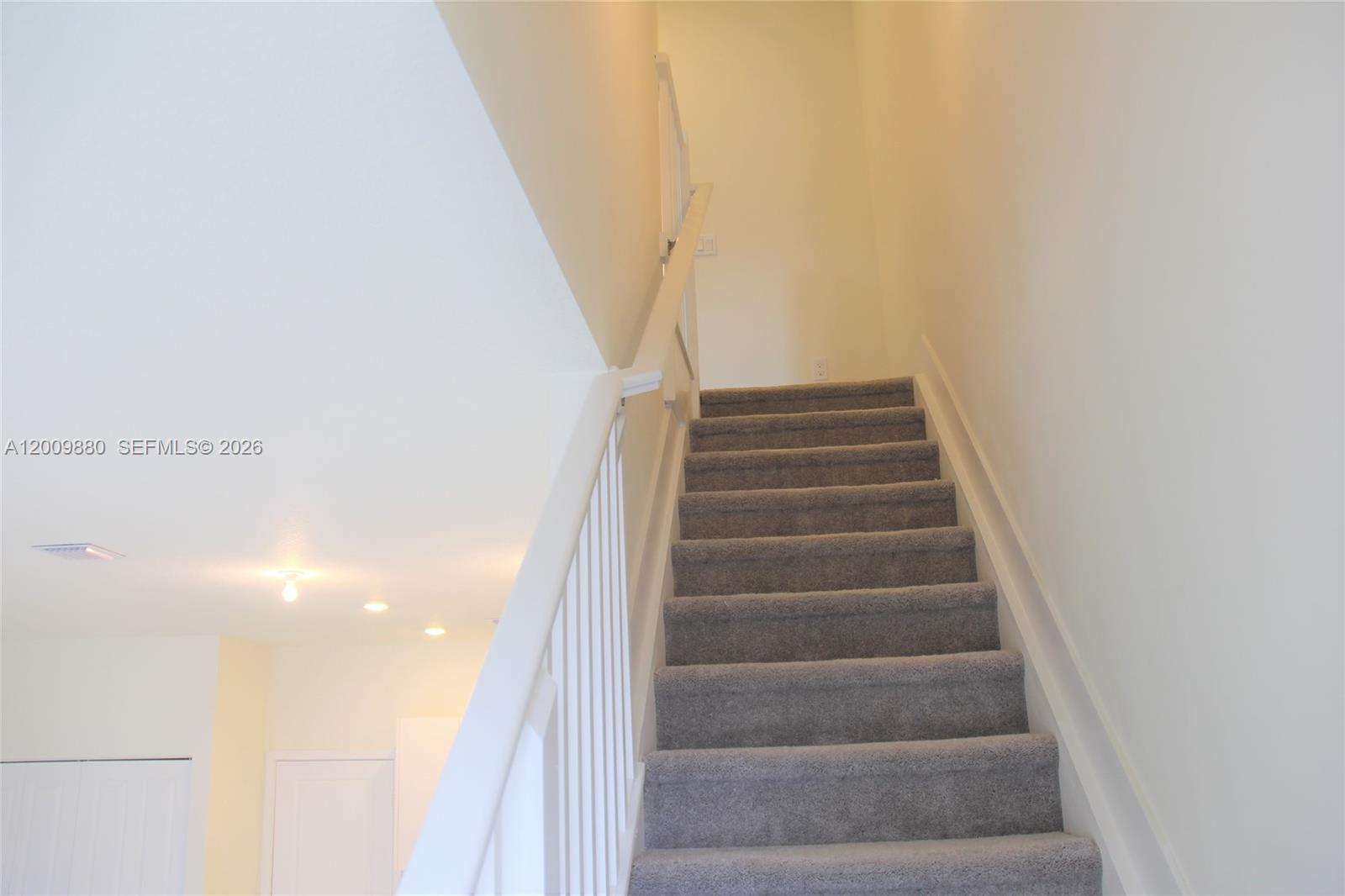 A carpeted staircase with a white railing leads to an upper level — 4272 NW 82nd Ave # 4272, Doral FL 33166, DORAL, FL