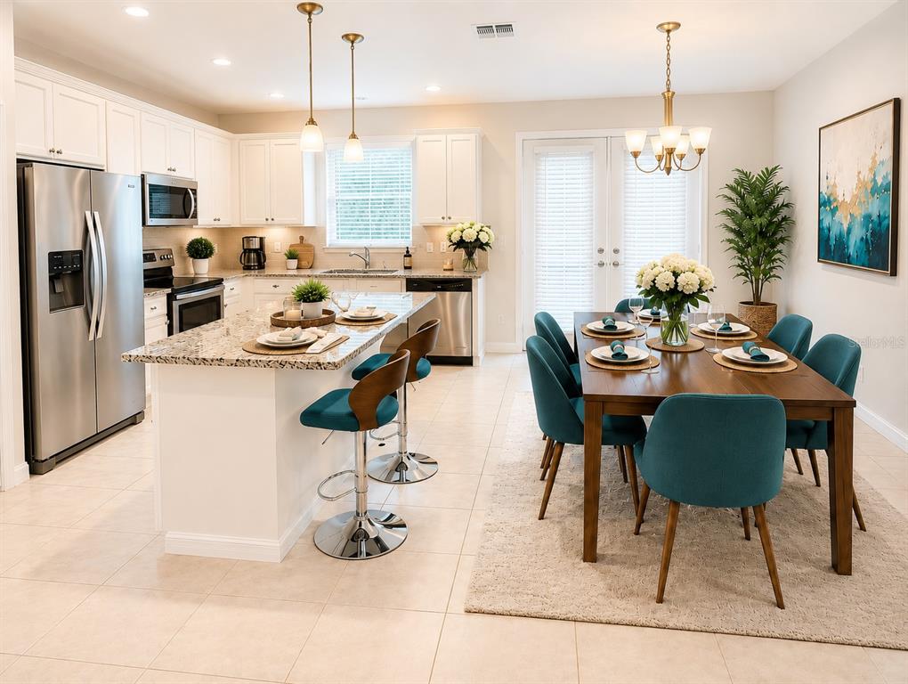A kitchen with white cabinets and granite countertops opens into a dining area with teal chairs — 6910 TUSSILAGO WAY, ORLANDO, FL