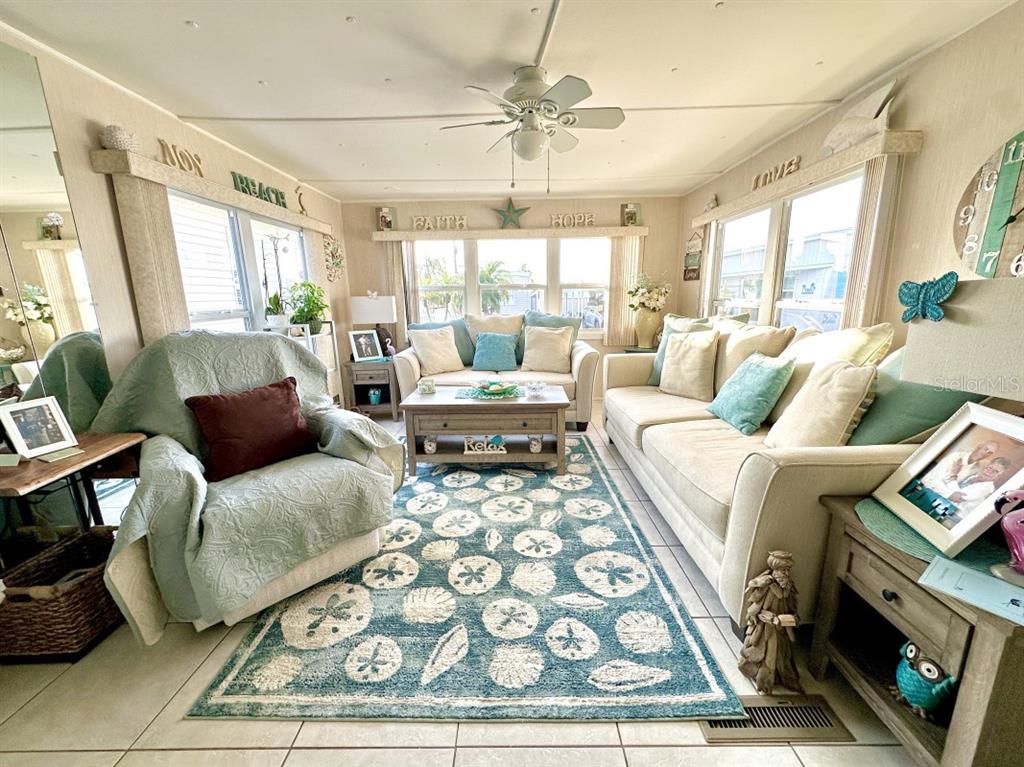 A living room features a blue patterned rug, a sofa, a loveseat, and an armchair — 2094 DETROITER STREET, SARASOTA, FL