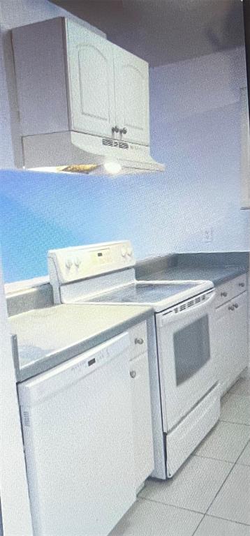 A kitchen features white cabinets, a white stove, a dishwasher, and gray countertops — 900 S PENINSULA DRIVE UNIT 111, DAYTONA BEACH, FL