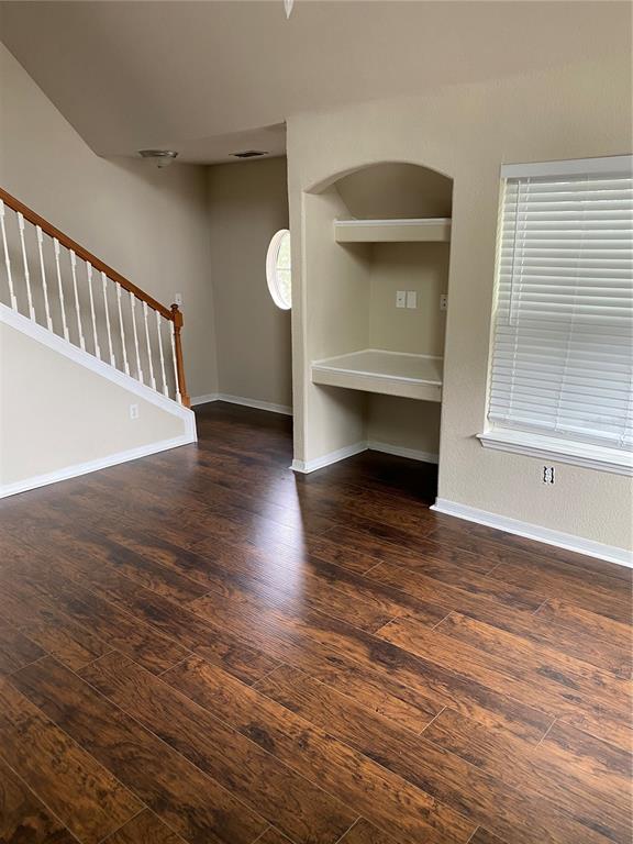 A room with dark wood-look flooring, a staircase with white railings, and a built-in desk — 3417 WESTCHESTER SQUARE BOULEVARD UNIT 204, ORLANDO, FL