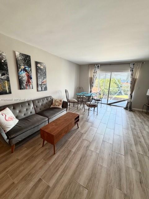 A living room features a grey sofa, a wooden coffee table, and a dining area — 215 SE 3rd Ave # 306C, Hallandale Beach FL 33009, HALLANDALE BEACH, FL