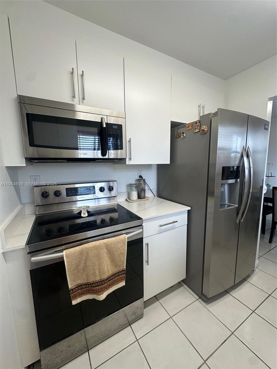 A kitchen features white cabinets, stainless steel appliances, and light-colored countertops — 13671 SW 62nd St # 1, Miami FL 33183, MIAMI, FL