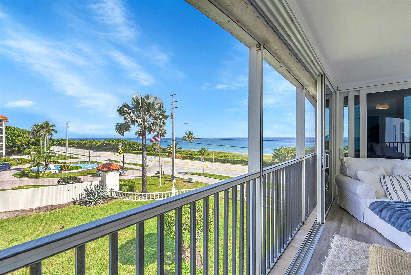 A screened-in balcony overlooks a coastal road, palm trees, and the ocean — 2871 N Ocean Boulevard # D302, Boca Raton FL 33431, BOCA RATON, FL