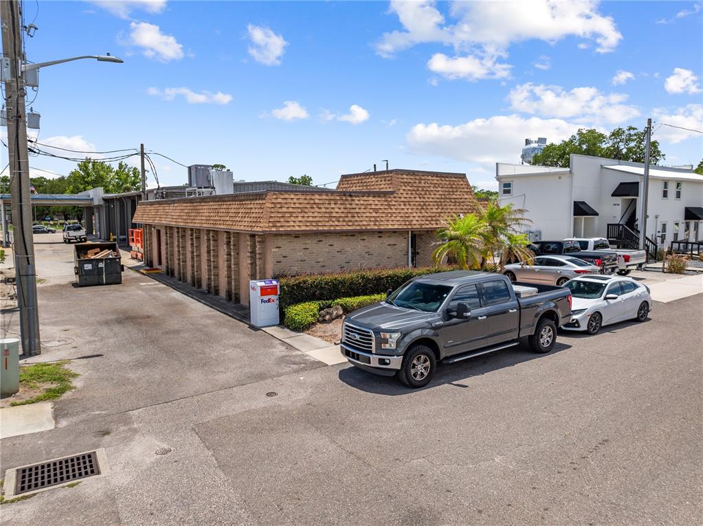 An exterior view of a single-story brick commercial building with a brown mansard roof — 1211 12TH STREET, ST CLOUD, FL