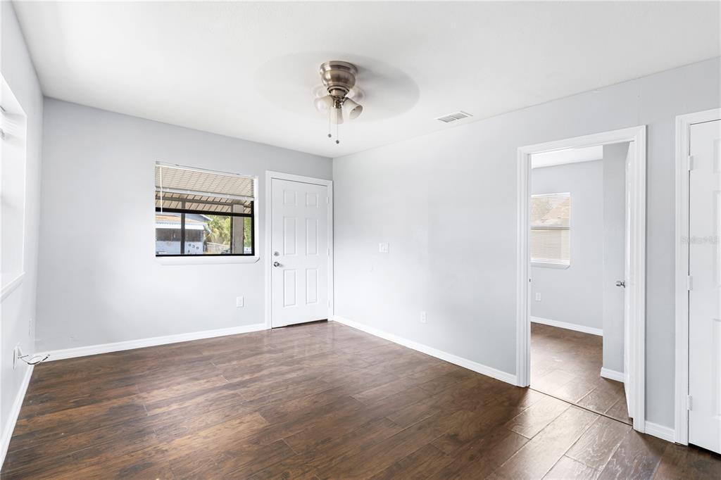 An empty room with light gray walls, dark wood-look tile flooring, and a ceiling fan — 638 W 8TH STREET, LAKELAND, FL