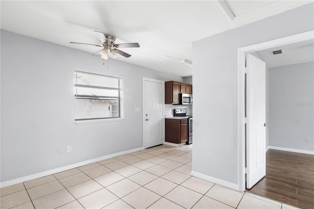 A tiled dining area features a ceiling fan, a window, and an adjacent kitchen — 638 W 8TH STREET, LAKELAND, FL