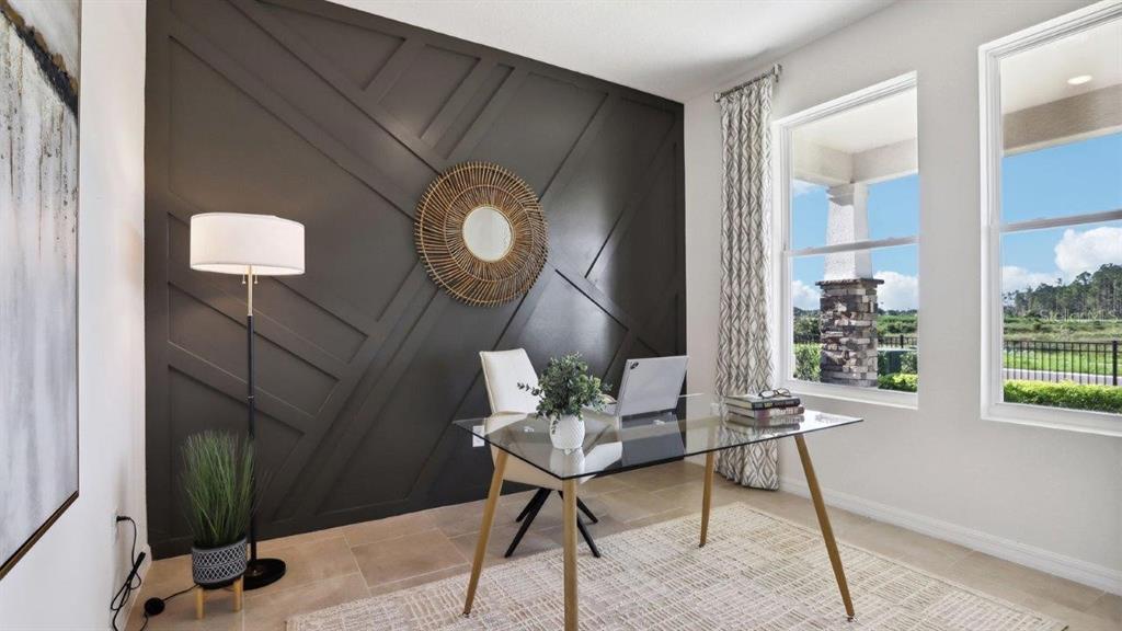A home office features a dark accent wall with geometric molding, a glass desk, and windows — 35608 LOWERY TRAIL, ZEPHYRHILLS, FL